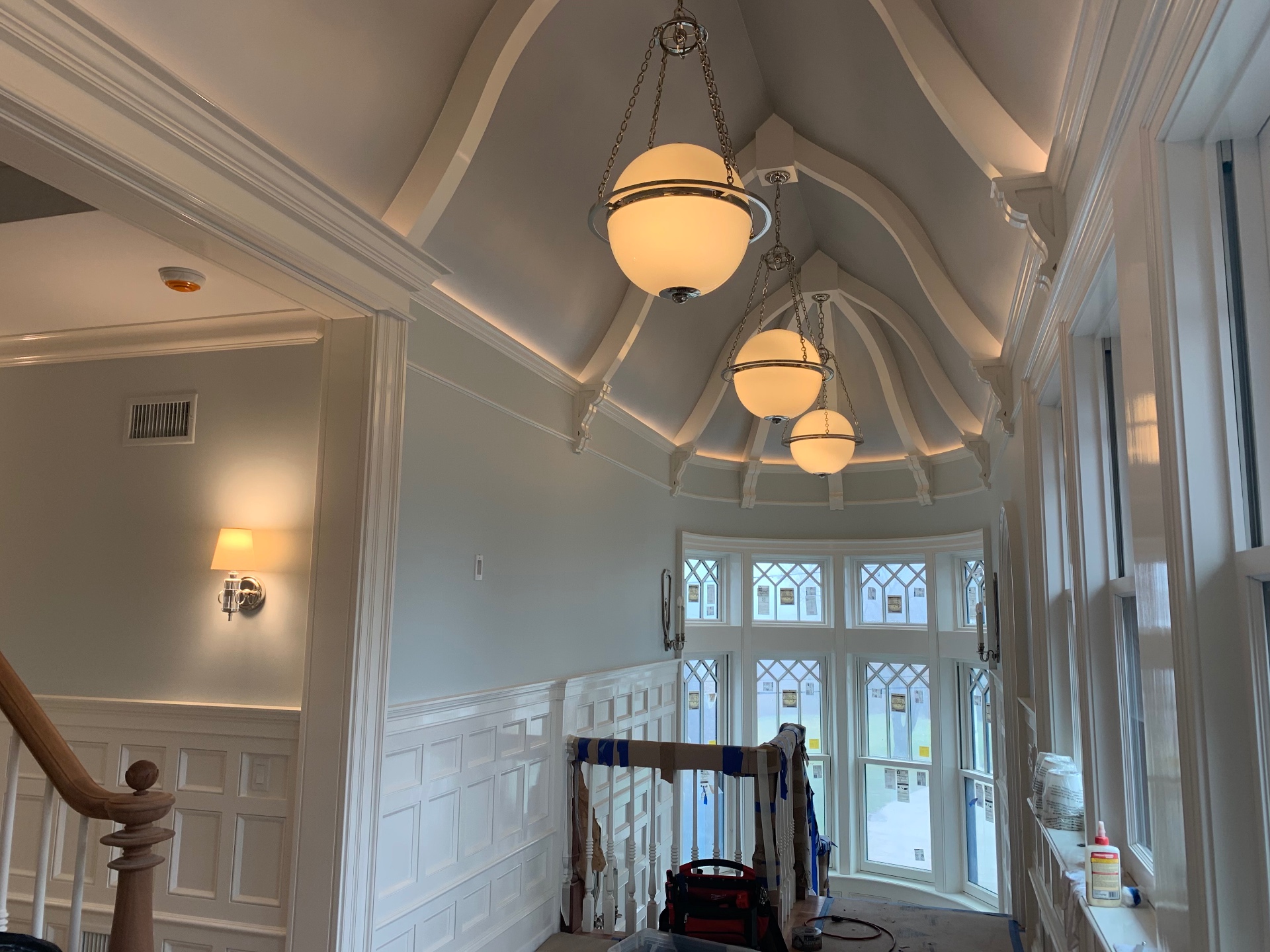 Designer pendant lighting in a coffered rotunda ceiling installed by Andrew
