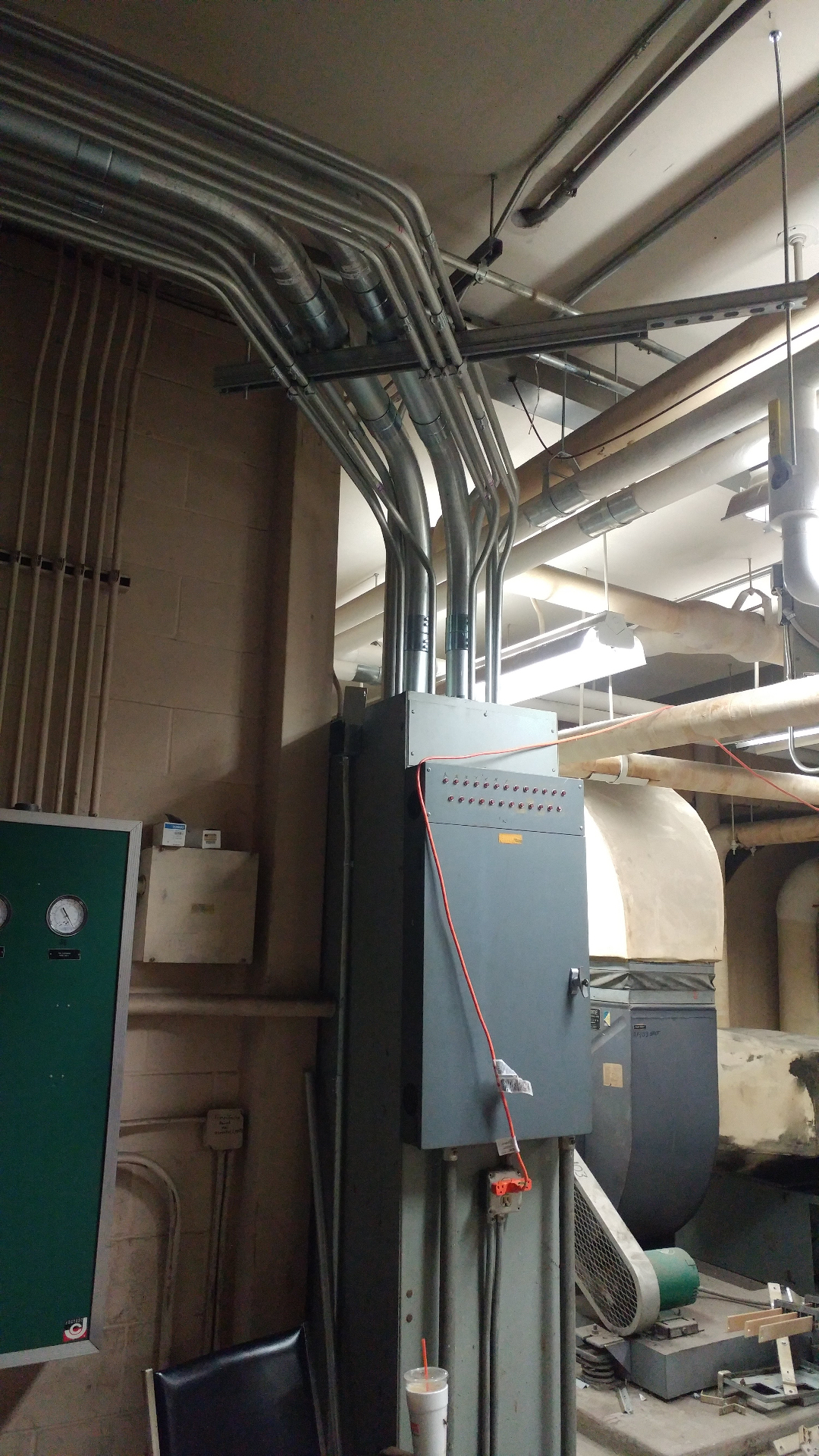 Industrial control cabinet with indicator lights and overhead rigid conduit feeders